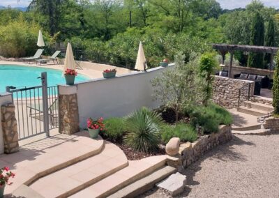 Vue sur la piscine chauffée et les jardins aménagés du Mas de la Colombe à Grospierres.