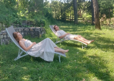 Espace de détente avec transats dans le jardin arboré du Mas de la Colombe à Grospierres.